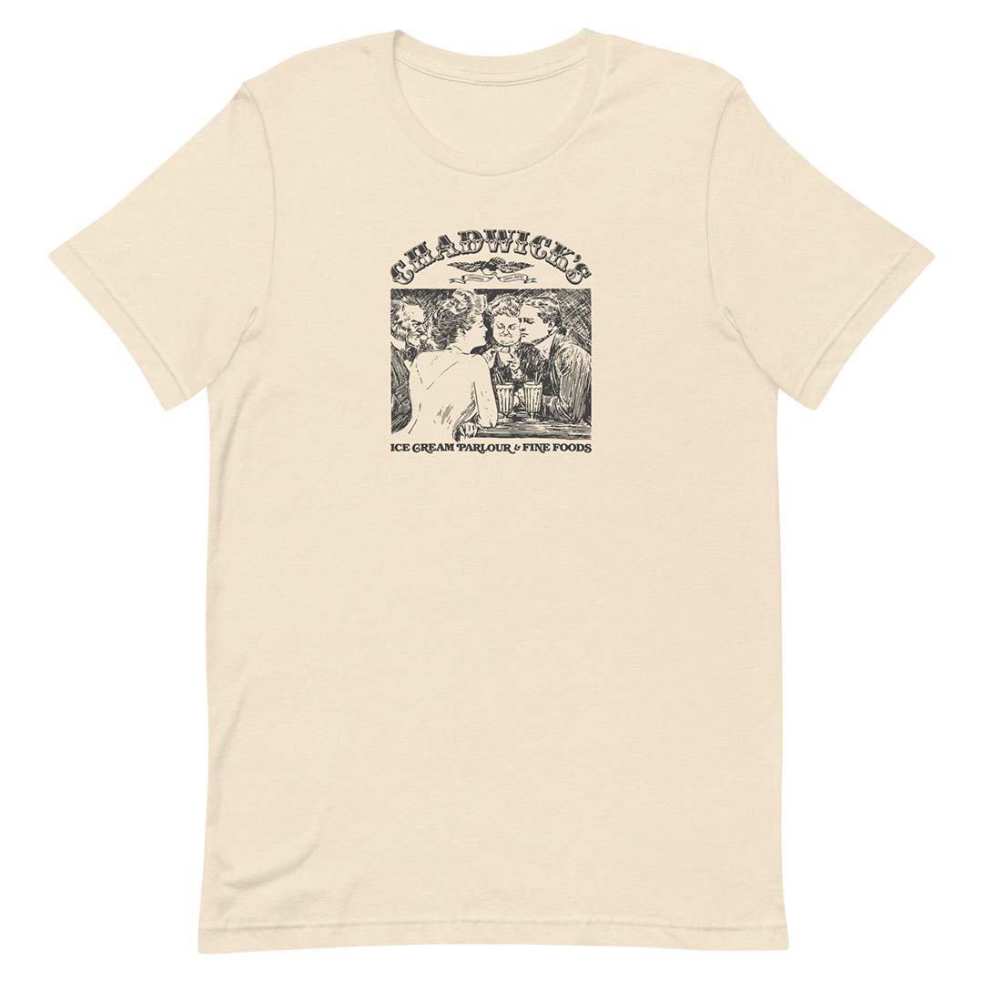 A cream-colored short-sleeve t-shirt with a black graphic print on the front. The graphic features the text 'CHADWICK'S' above an illustration of people eating ice cream, with 'ICE CREAM PARLOUR & FINE FOODS' printed below.