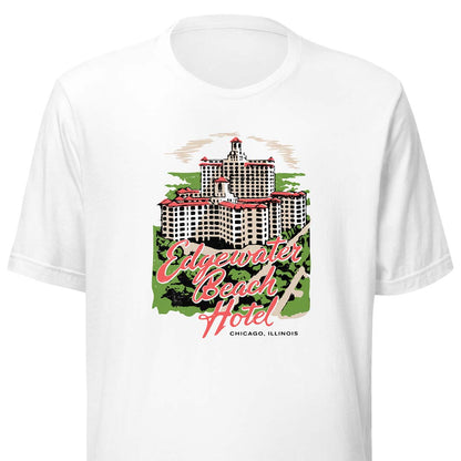 A white short-sleeve crewneck t-shirt featuring a vintage-style graphic of the Edgewater Beach Hotel in Chicago, Illinois. The graphic includes a detailed illustration of the hotel building, green trees, and pink script text reading 'Edgewater Beach Hotel' with 'CHICAGO, ILLINOIS' written below.