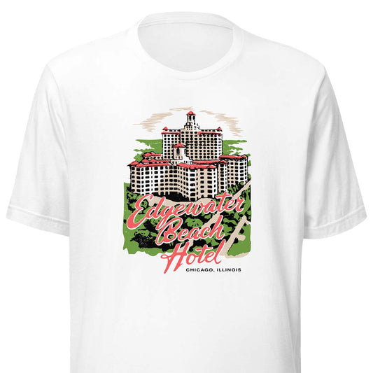 A white short-sleeve crewneck t-shirt featuring a vintage-style graphic of the Edgewater Beach Hotel in Chicago, Illinois. The graphic includes a detailed illustration of the hotel building, green trees, and pink script text reading 'Edgewater Beach Hotel' with 'CHICAGO, ILLINOIS' written below.