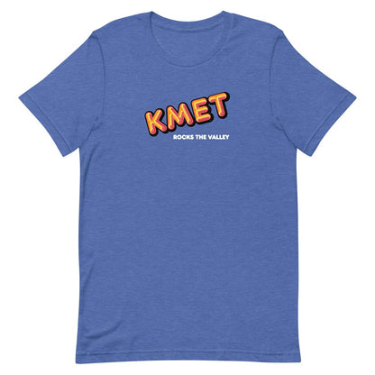 A heather blue short-sleeve t-shirt with a graphic on the chest reading 'KMET' in orange and yellow with a black outline, and 'ROCKS THE VALLEY' in white underneath, shown on a plain white background.