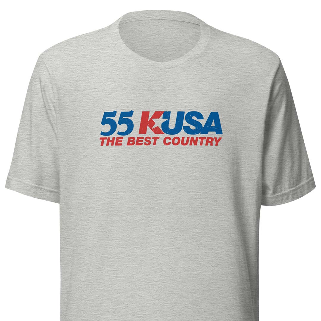 A light heather gray short-sleeve t-shirt with a graphic on the chest reading '55 KUSA THE BEST COUNTRY' in blue and red text.