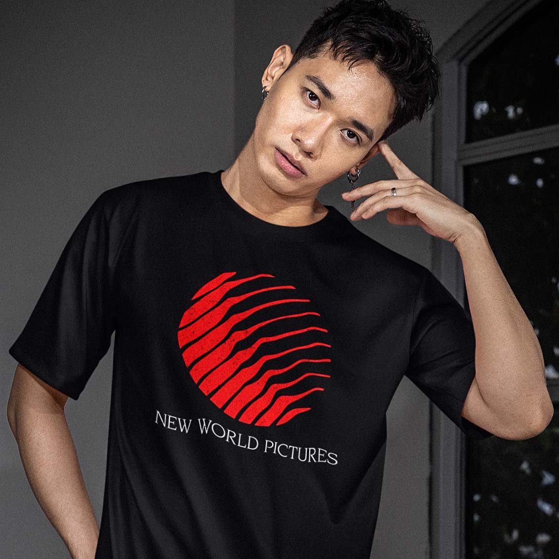 A black short-sleeve crewneck t-shirt featuring a red circular graphic made of diagonal stripes and the text 'NEW WORLD PICTURES' printed in white below it.