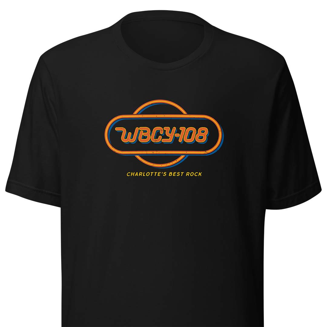 A black short-sleeve crewneck t-shirt featuring a retro-style orange and blue graphic on the chest with the text 'WBCY-108' and 'CHARLOTTE'S BEST ROCK'.