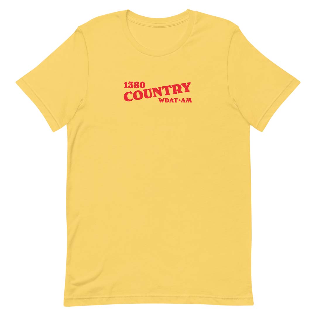 A yellow short-sleeve crewneck t-shirt with red text on the chest reading '1380 COUNTRY' and 'WDAT-AM', displayed on a solid white background.