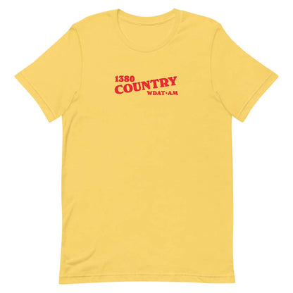 A yellow short-sleeve crewneck t-shirt with red text on the chest reading '1380 COUNTRY' and 'WDAT-AM', displayed on a solid white background.