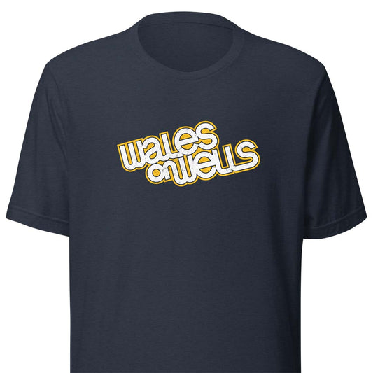 A navy blue short-sleeve t-shirt with a retro-style graphic on the chest reading 'wales on wells' in white bubble letters with a yellow outline.