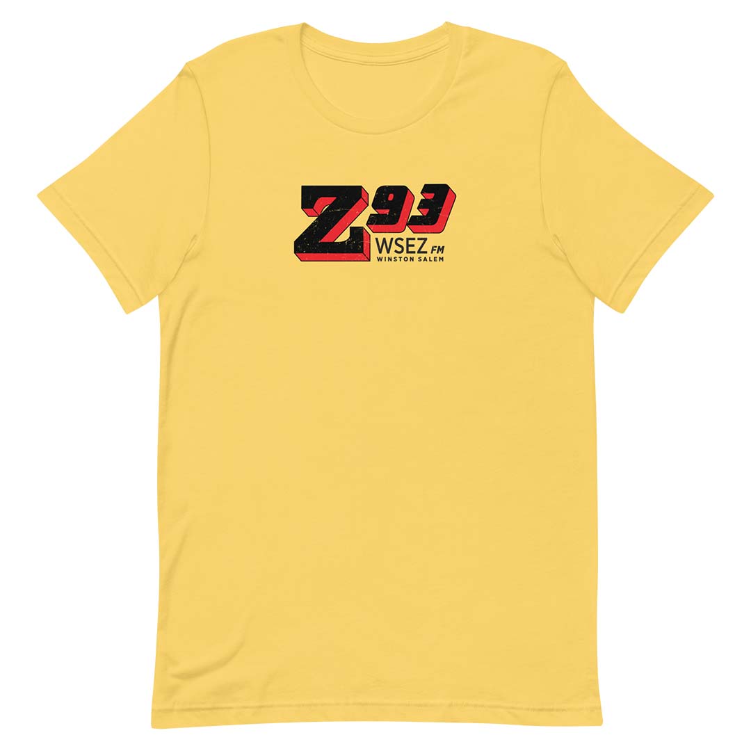 A yellow short-sleeve crewneck t-shirt featuring a 'Z93 WSEZ FM' graphic printed on the chest in black and red, displayed against a solid white background.